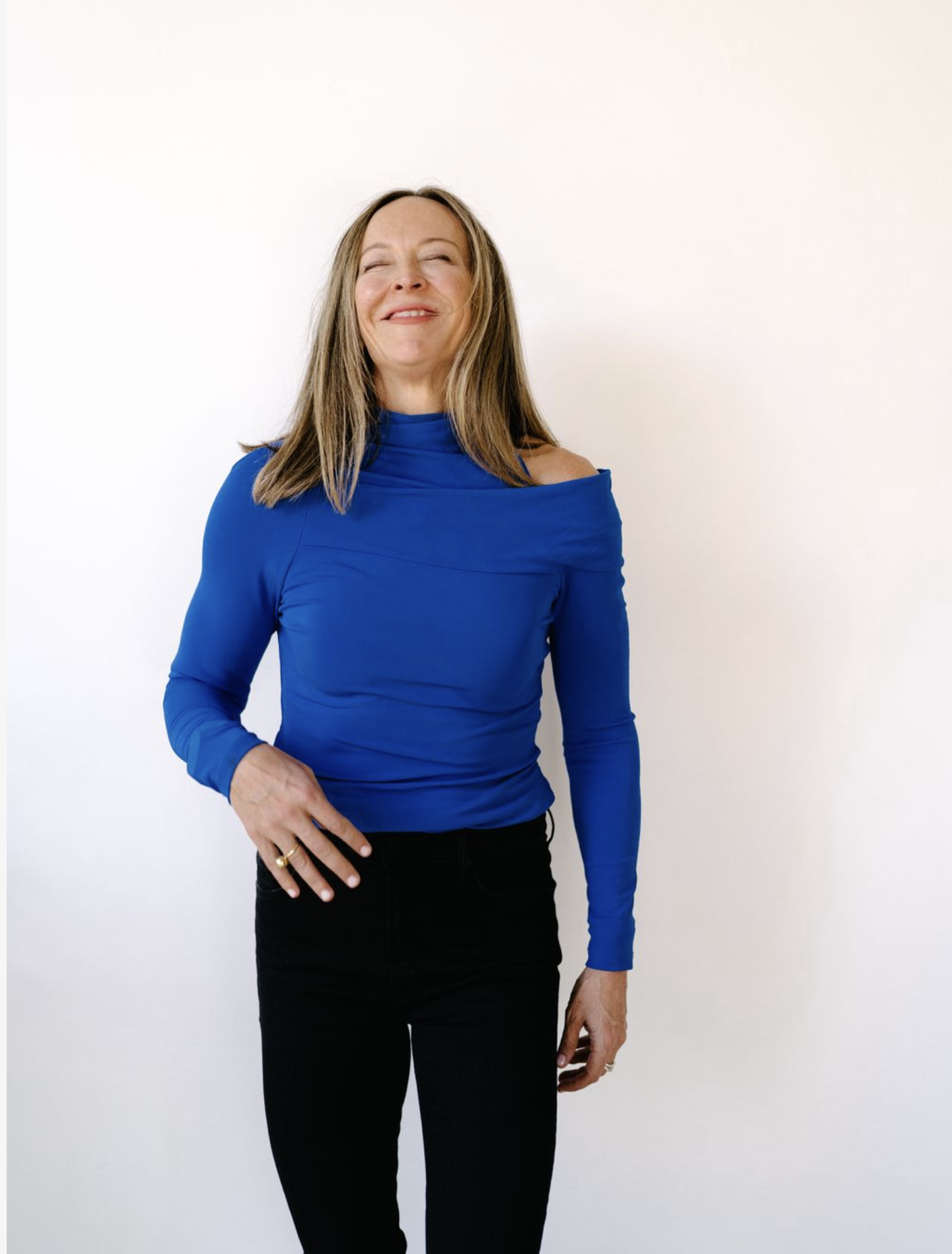 Anese Cavanaugh in a blue top, eyes closed with a serene, joyful smile