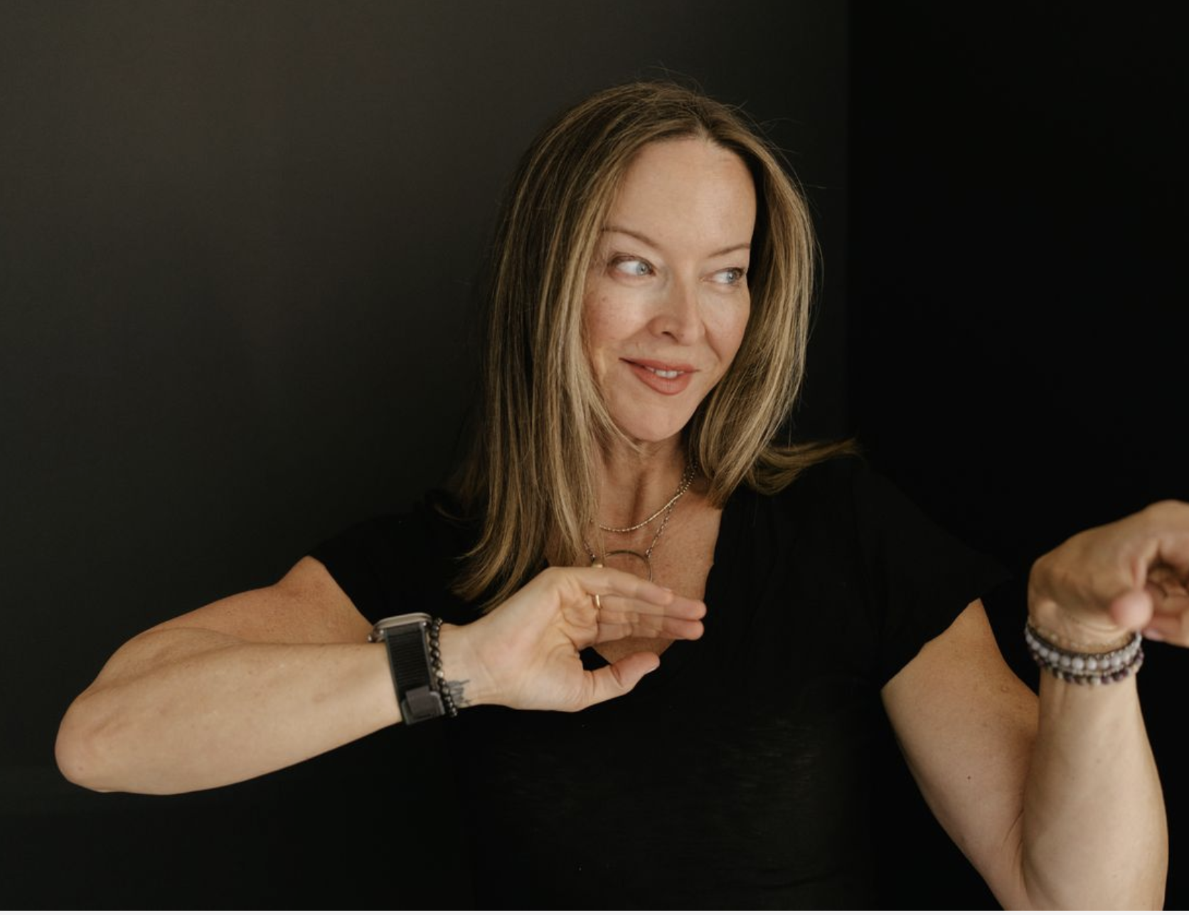 Anese Cavanaugh smiling and looking off camera while gesturing